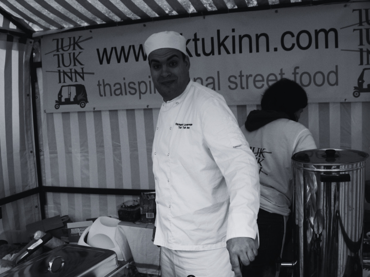 Richard Liverman is dressed in chefs whites and working on a street food stall.