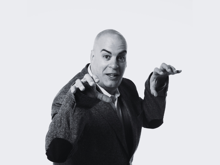 Richard Liverman holds his hands up like claws. He intends to look frightening but is also smiling and is clearing making the gesture as a joke.